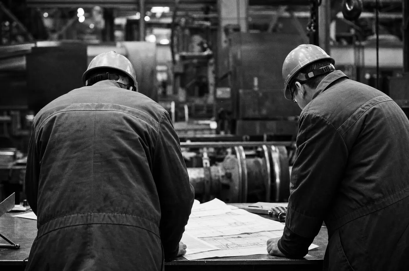 Dos ingenieros revisando planos sobre una mesa en planta