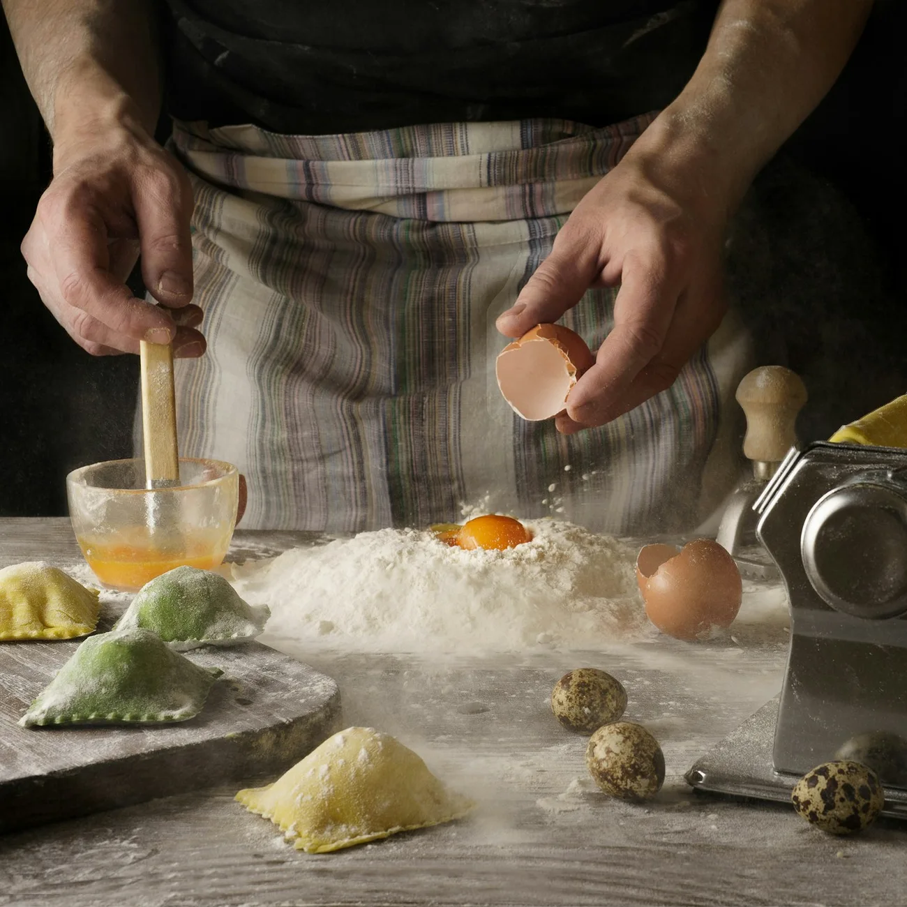 Manos preparando pasta fresca con huevos y harina sobre una mesa de madera