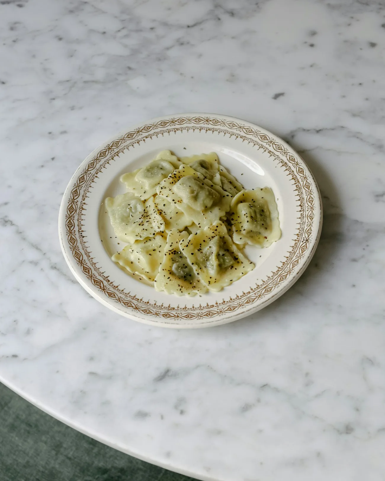 Ravioli artesanales con mantequilla y pimienta en un plato de porcelana