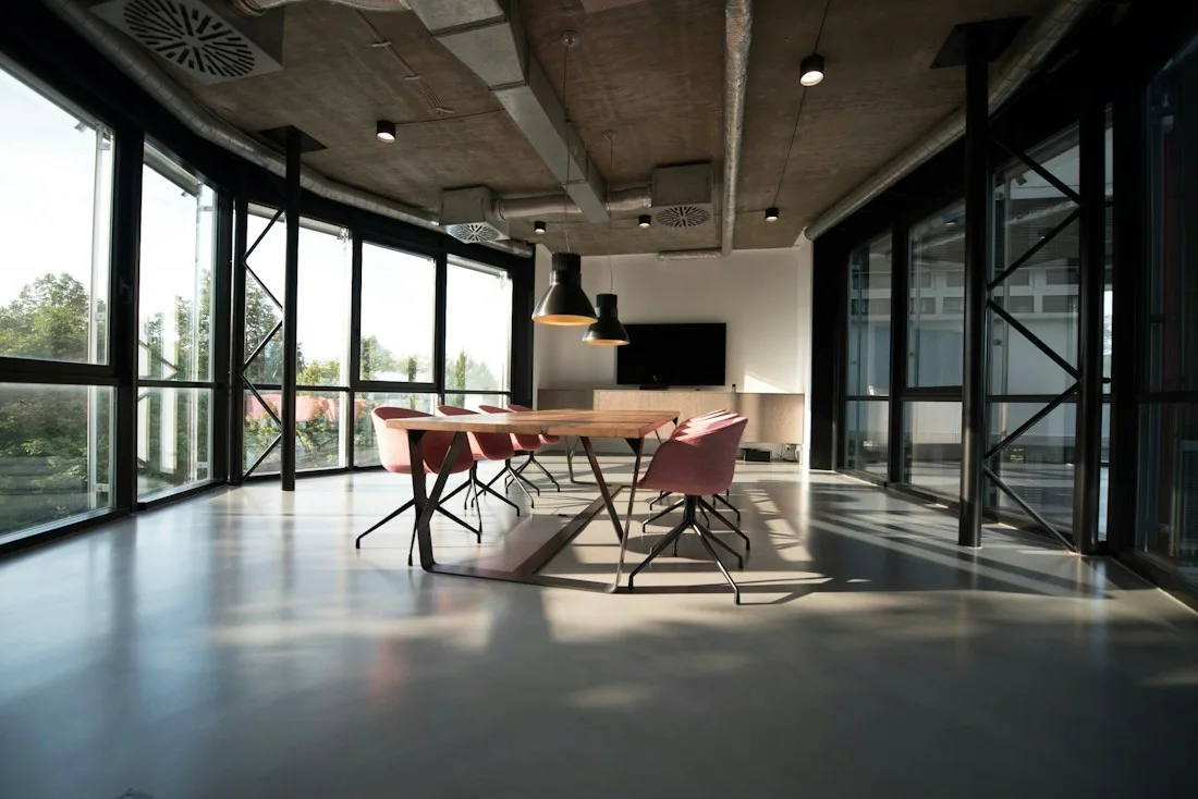Espacio de trabajo con materiales naturales, mesas compartidas y luz de día