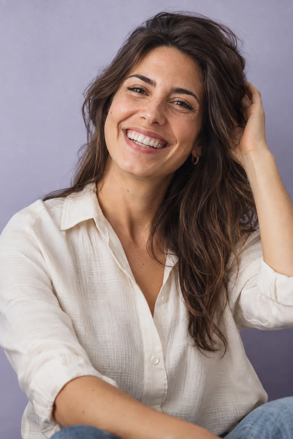 Retrato editorial de una mujer sonriente sobre fondo lavanda